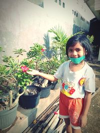 Portrait of happy girl holding potted plant