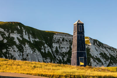 Low angle view of built structure on field against clear sky