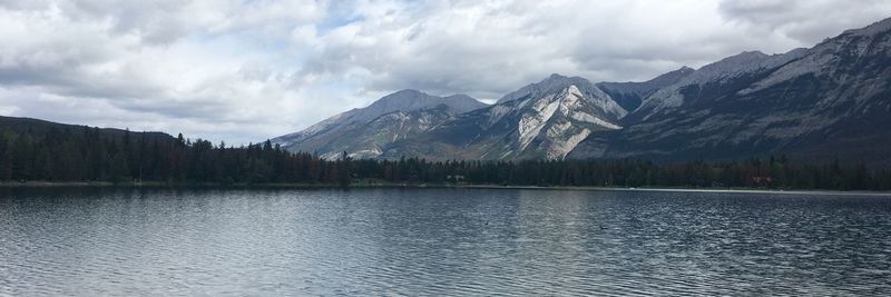 Scenic view of lake by mountains against sky