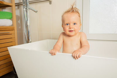 Portrait of cute baby boy in bathroom