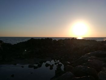 Scenic view of sea against clear sky during sunset