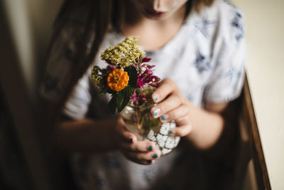 Little girl makes a flower bouquet in kitchen