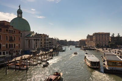 Boats in canal amidst buildings in city