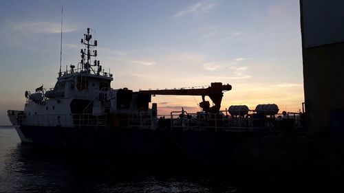 Silhouette ship in sea against sky during sunset