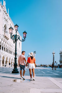 Couple on street against buildings in city