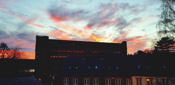 Silhouette built structure against dramatic sky