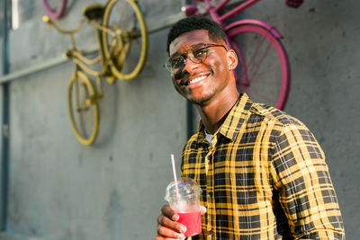 Portrait of young man drinking water in factory