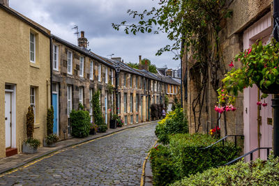 Footpath amidst buildings against sky