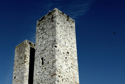 Low angle view of built structure against blue sky during sunny day