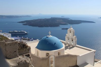 Panoramic view of sea and mountains against blue sky in santorini greece