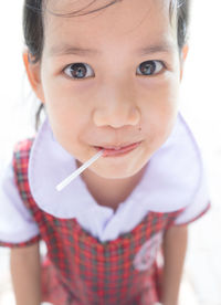 Close-up portrait of cute girl eating lollipop