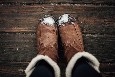 Low section of person standing on hardwood floor