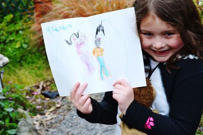 Portrait of smiling girl holding camera