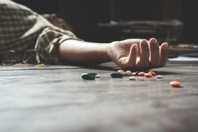 Man lying by pills on floor at home