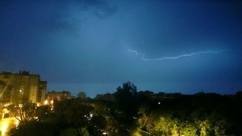 Lightning over city against sky at night