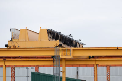 Low angle view of crane against sky