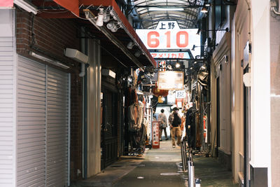 People on alley amidst buildings in city