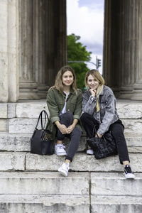 Portrait of female friends sitting on steps