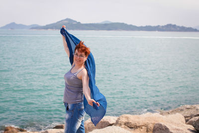 Full length of young woman standing on sea shore