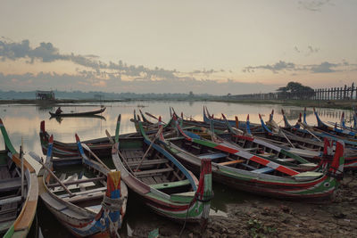 Boats moored in sea at sunset