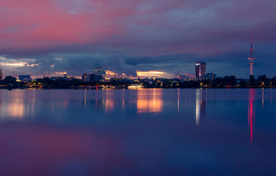 Lake by heinrich-hertz-turm against cloudy sky at dusk