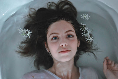 Portrait of young woman lying in bathtub