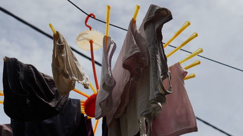 Low angle view of clothes hanging on clothesline against sky