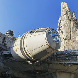 Low angle view of old machinery against clear blue sky