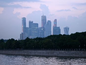 River by buildings against sky in city