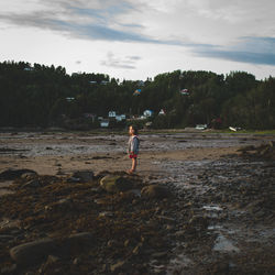 Full length of man standing on beach against sky