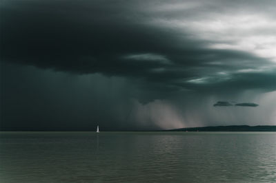 Scenic view of sea against storm clouds