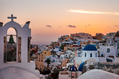 Buildings in town against sky during sunset