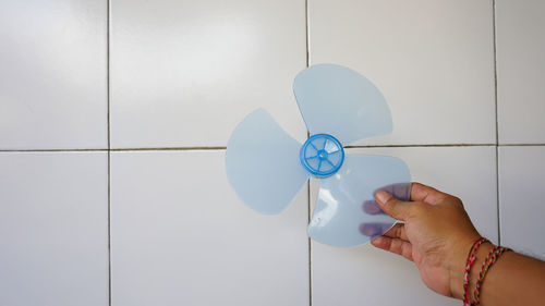 Midsection of person holding umbrella against wall
