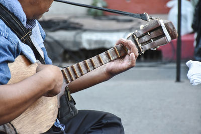 Midsection of man playing guitar