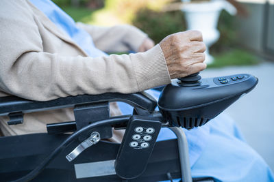 Midsection of senior woman sitting on wheelchair