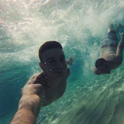 Low section of man swimming in sea