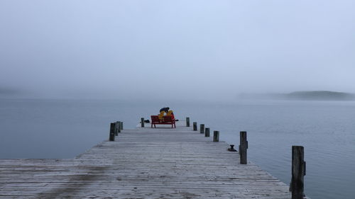 Adirondack chairs on dock in morning mist