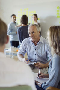 Businessman discussing with colleagues in board room