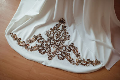Embroidery with gold and white beads and glass beads on the bride's wedding dress close-up