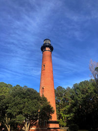 Low angle view of lighthouse by building against sky