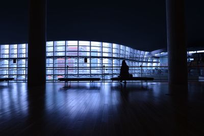 Silhouette woman sitting on bench at airport