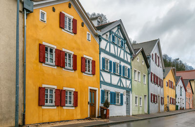 Residential buildings by street against sky