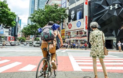 Rear view of people walking on city street