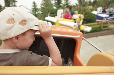 Close-up of cute boy sitting in ride