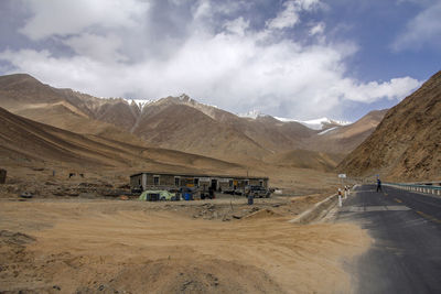 A flat newly built asphalt road calls the foot of the snowy mountain ahead