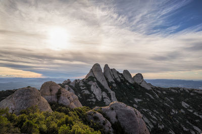 Rock formations on landscape against sky during sunset