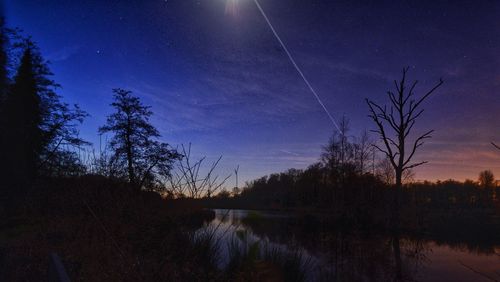 Scenic view of lake against sky at night