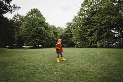 Young male child walking in the park on a cloudy day