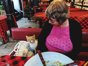 Woman with cat sitting at restaurant