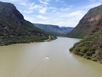 Scenic view of river amidst mountains against sky